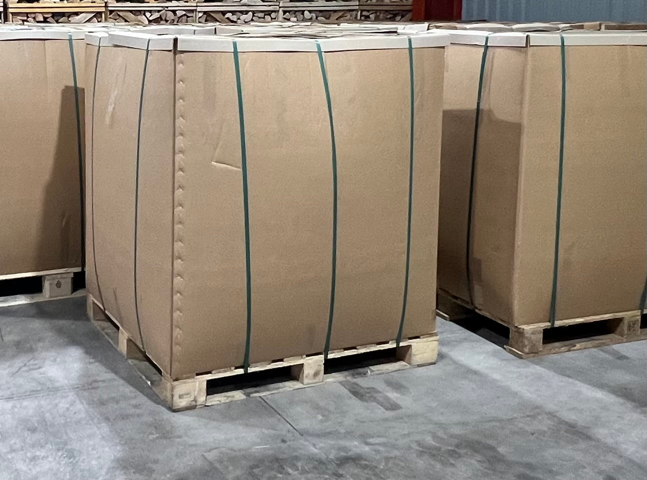 Bulk pallet boxes of Flamers natural firelighters strapped and stacked on pallets in a warehouse